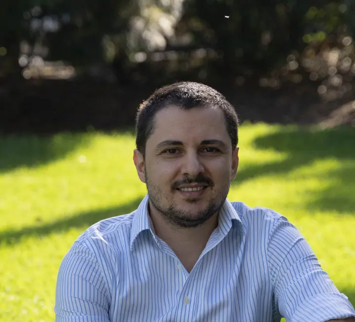 A man in a blue shirt sitting on the grass A man in a blue shirt sitting on the grass
