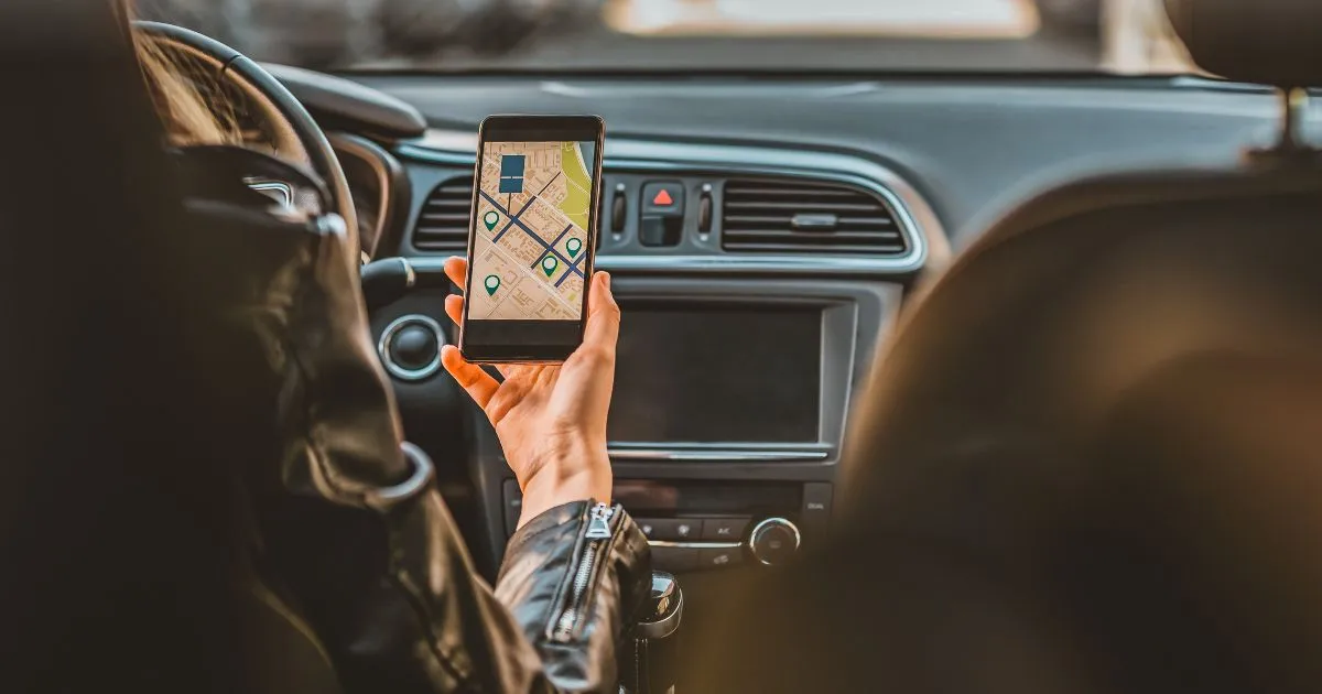 A Car Driver Using Her Phone To Navigate Parking Spaces A Car Driver Using Her Phone To Navigate Parking Spaces