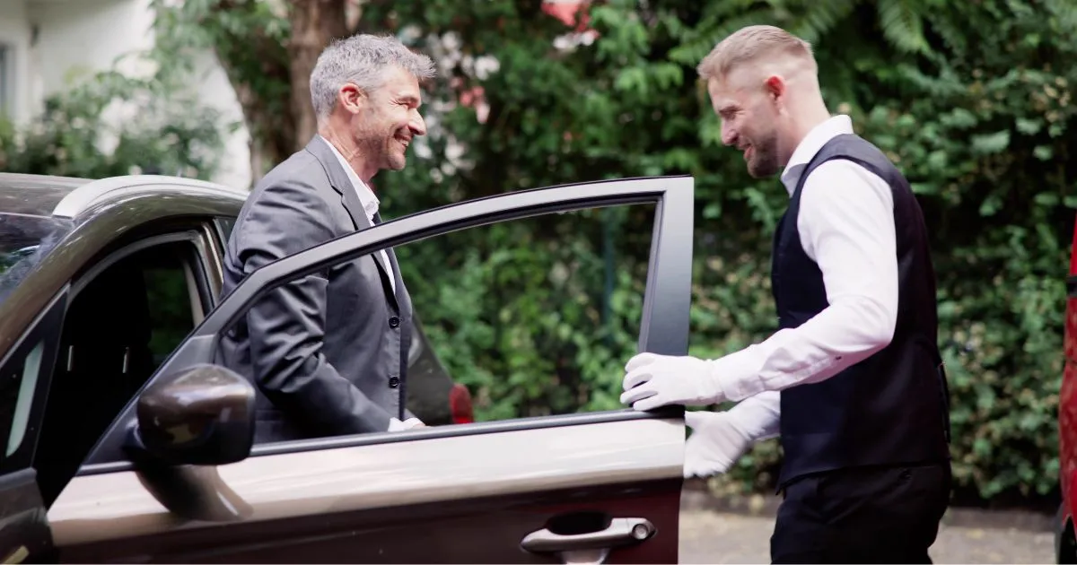 A Guest Stepping Out Of His Car Giving Charge To Valet Attendant A Guest Stepping Out Of His Car Giving Charge To Valet Attendant