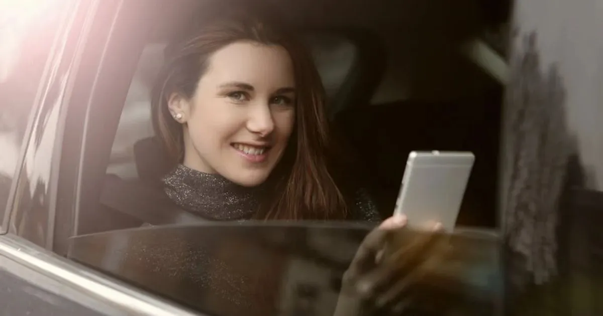 A Lady Enjoying Ridesharing In A Car With A Smiling Face And Phone In Her Hand A Lady Enjoying Ridesharing In A Car With A Smiling Face And Phone In Her Hand