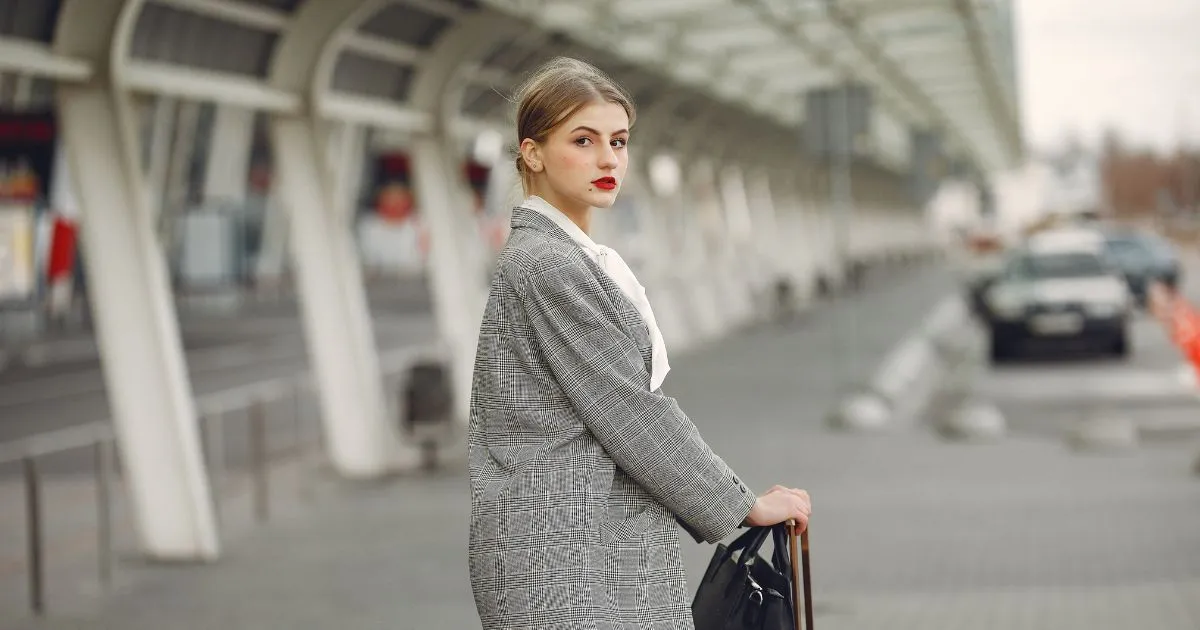 A Lady Posing With Her Suitcase After Parking Her Vehicle At An Airport Car Park