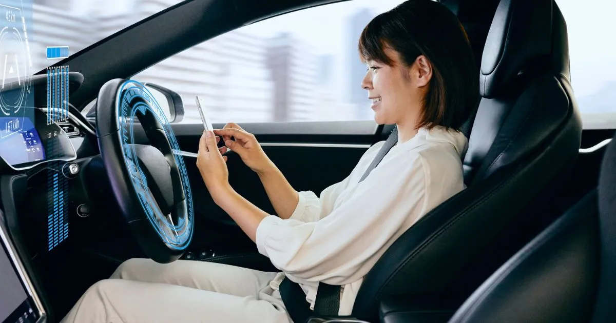 A Lady Wearing A White Track Suit Driving An Autonomous Vehicle