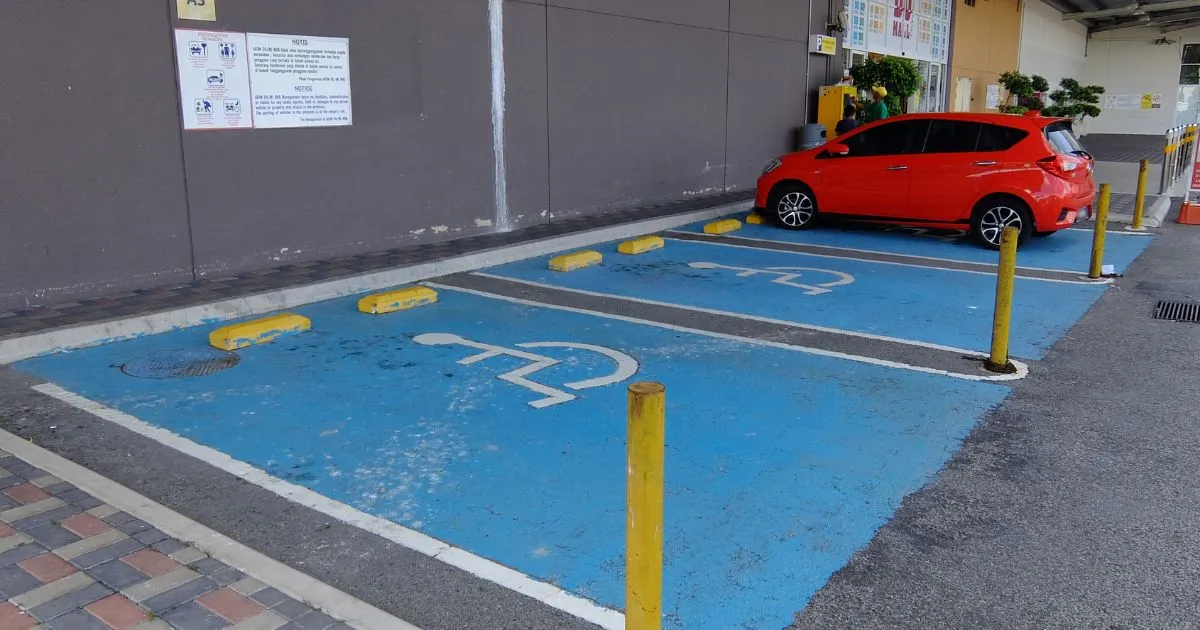 A Red Car Parked On An Accessible Parking Spot In A Car Park A Red Car Parked On An Accessible Parking Spot In A Car Park