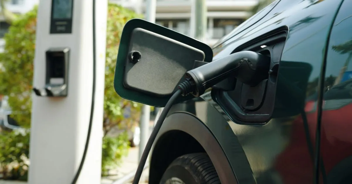 An Electric Vehicle Parked In A Car Park With Ev Charging Facilitiies An Electric Vehicle Parked In A Car Park With Ev Charging Facilitiies